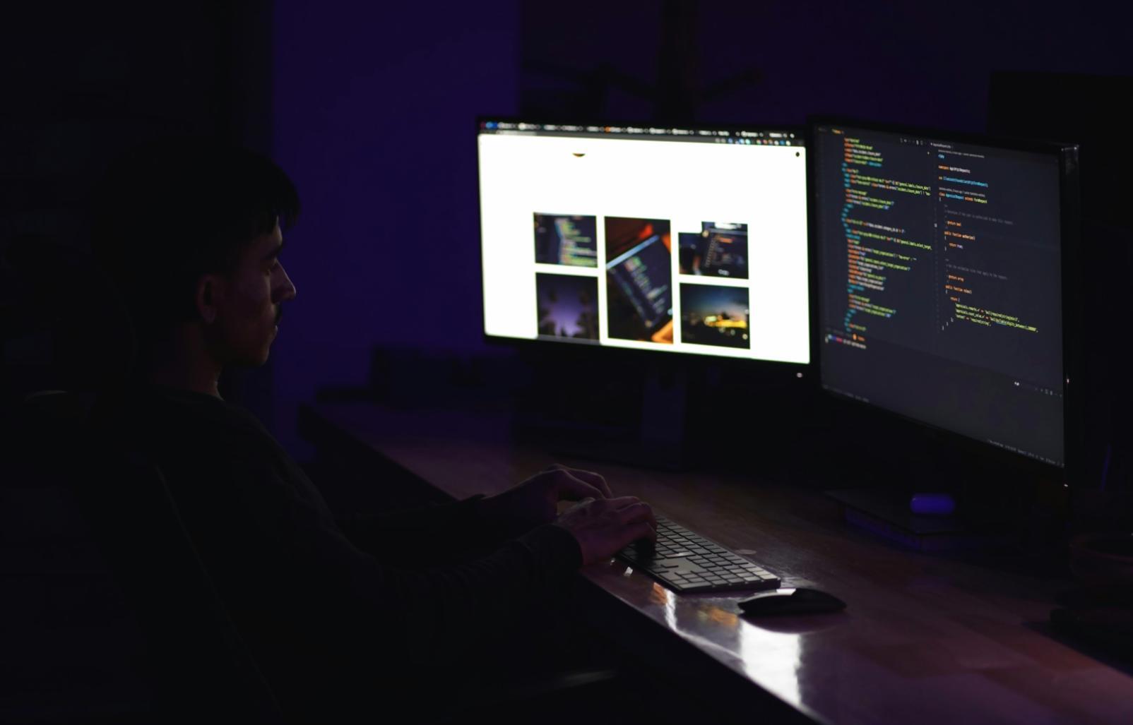 DevOps engineer working with multiple monitors showing deployment pipelines